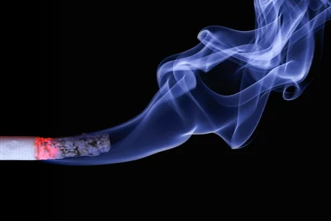 A lit cigarette emits smoke.